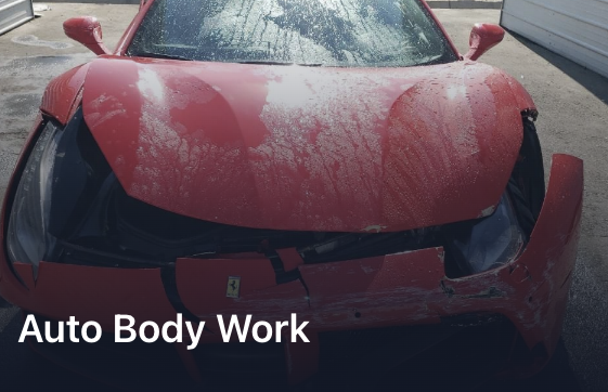 Damaged red sports car with a crumpled hood and visible dirt.